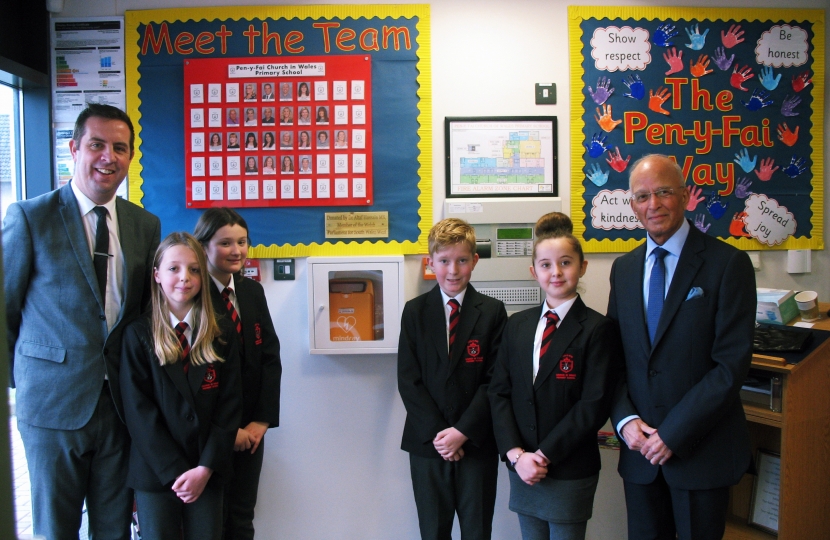 Regional Senedd member Altaf Hussain has donated defibrillators to two schools within Bridgend county borough.