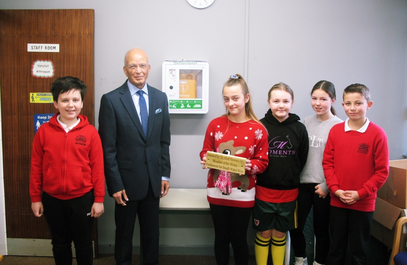 Regional Senedd member Altaf Hussain has donated defibrillators to two schools within Bridgend county borough.