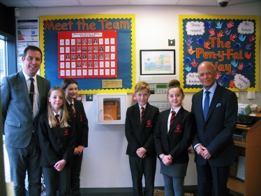 Regional Senedd member Altaf Hussain has donated defibrillators to two schools within Bridgend county borough.